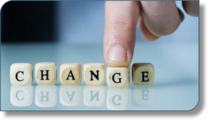 Photo of lettered dice arranged to spell "CHANGE" with a finger resting on the letter "G"