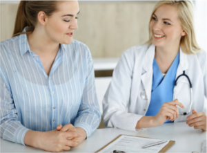 Photo of two females talking to each other. One appears to be a physician.