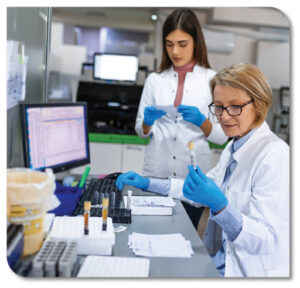 two women using a computer in a laboratory accessioning samples