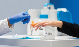 Close up image of scientist collecting finger stick blood sample.